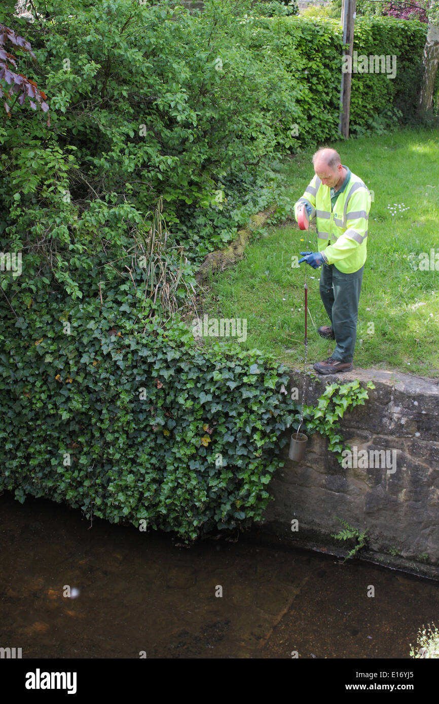 Un'agenzia per l'ambiente lavoratore prende un campione di acqua dal fiume Derwent a Baslow, Peak District, Derbyshire, England, Regno Unito Foto Stock