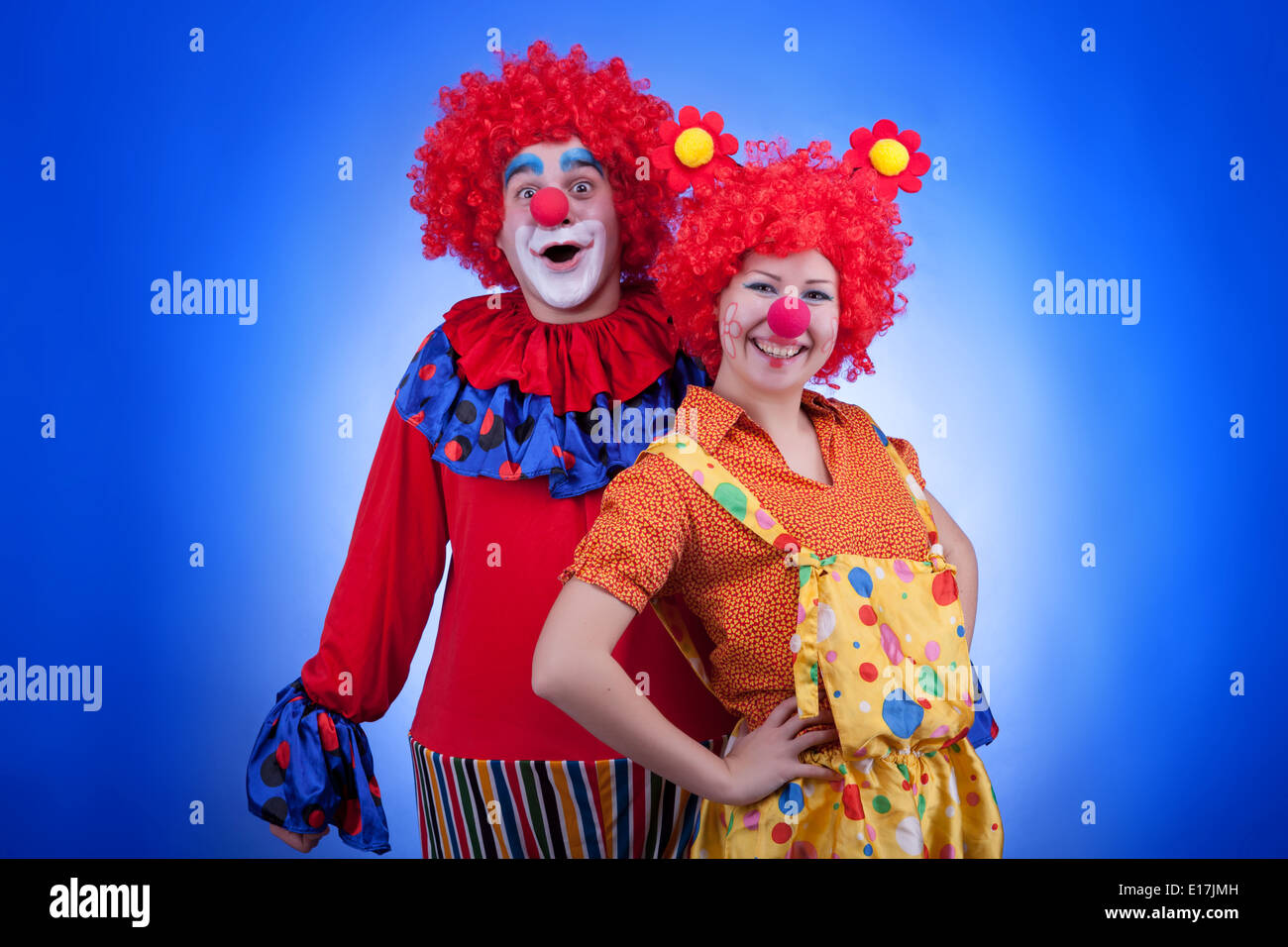Clown matura in costumi su sfondo blu. Studio di illuminazione professionale. Colori brillanti Foto Stock