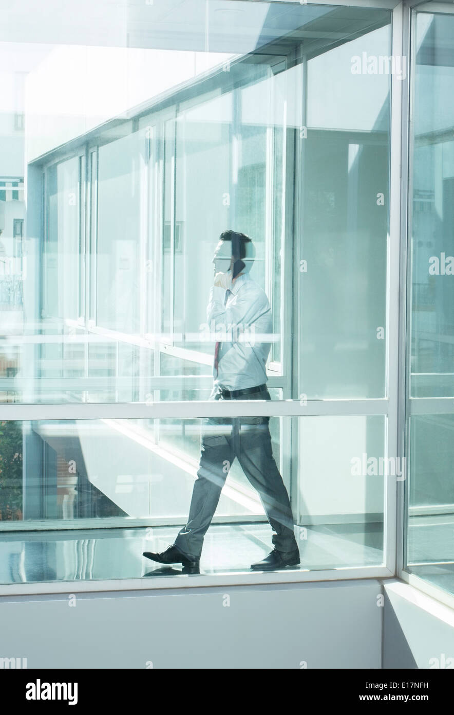 Imprenditore parlando al cellulare in un ufficio moderno Foto Stock