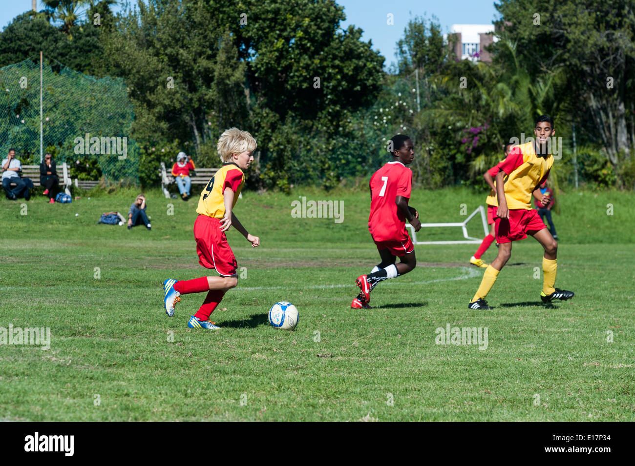 Junior football giocatori inseguono il pallone, Cape Town, Sud Africa Foto Stock