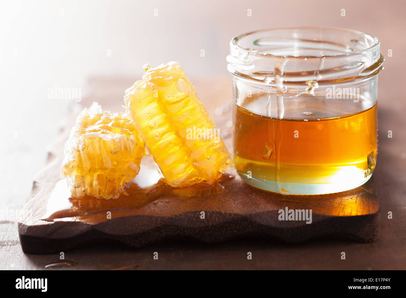 Nido e miele in vaso su sfondo di legno Foto Stock