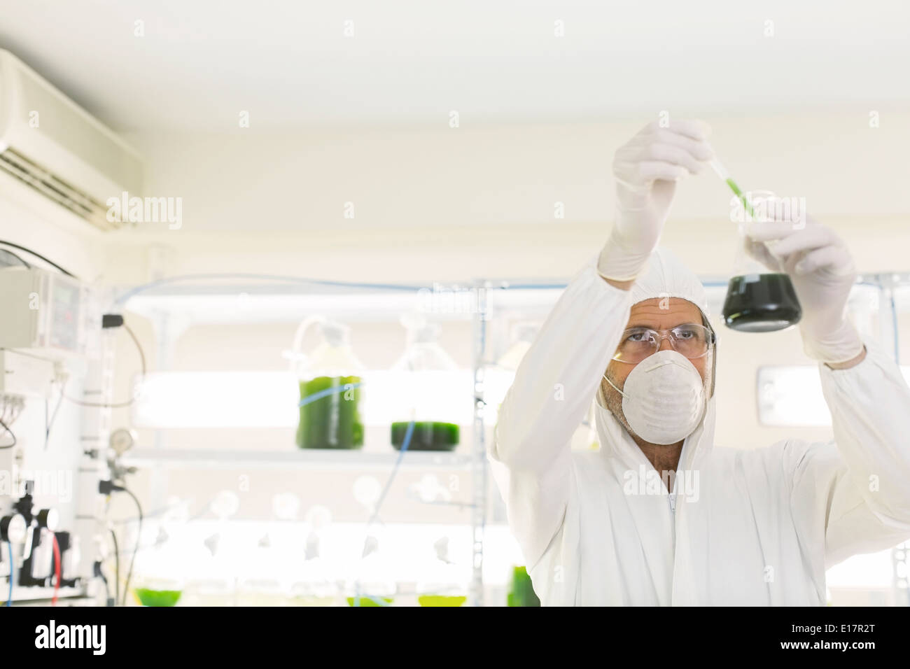 Scienziato in clean suit conducendo esperimento scientifico in laboratorio Foto Stock