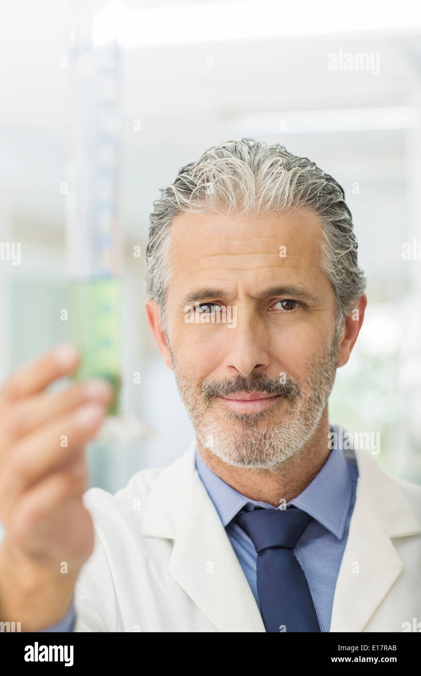 Ritratto di fiducioso scienziato tubo di contenimento con il liquido verde Foto Stock