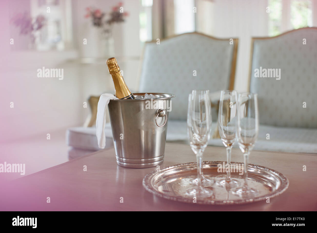 Champagne in argento secchio accanto a champagne flauti Foto Stock