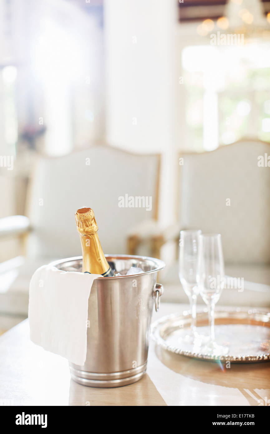 Champagne in argento secchio accanto a champagne flauti Foto Stock