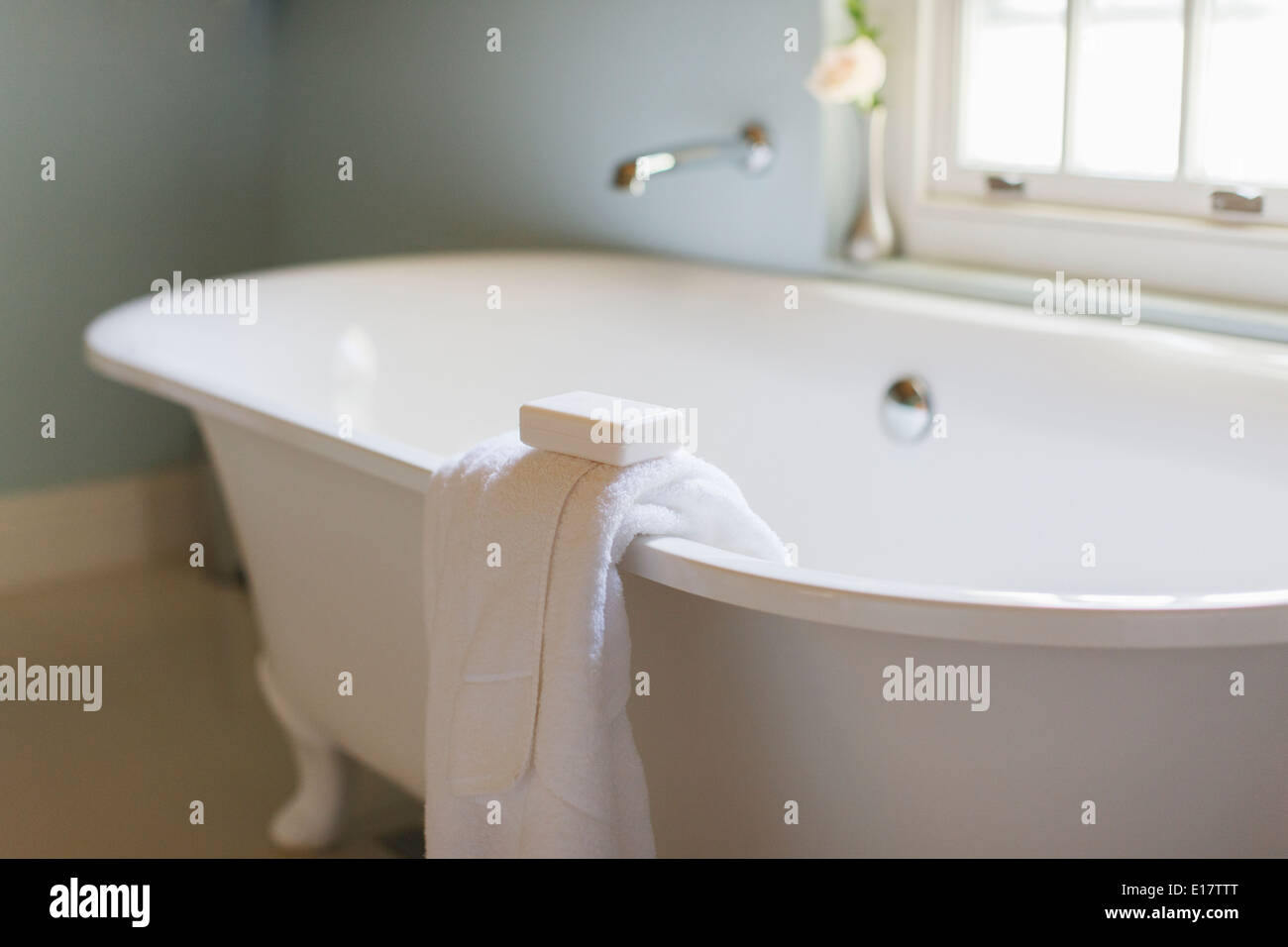 Barretta di sapone e asciugamano sulla battuta del piede ad artiglio vasca Foto Stock