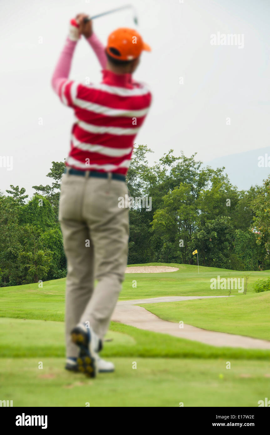 Il Golfer tee-shot al foro. Foto Stock