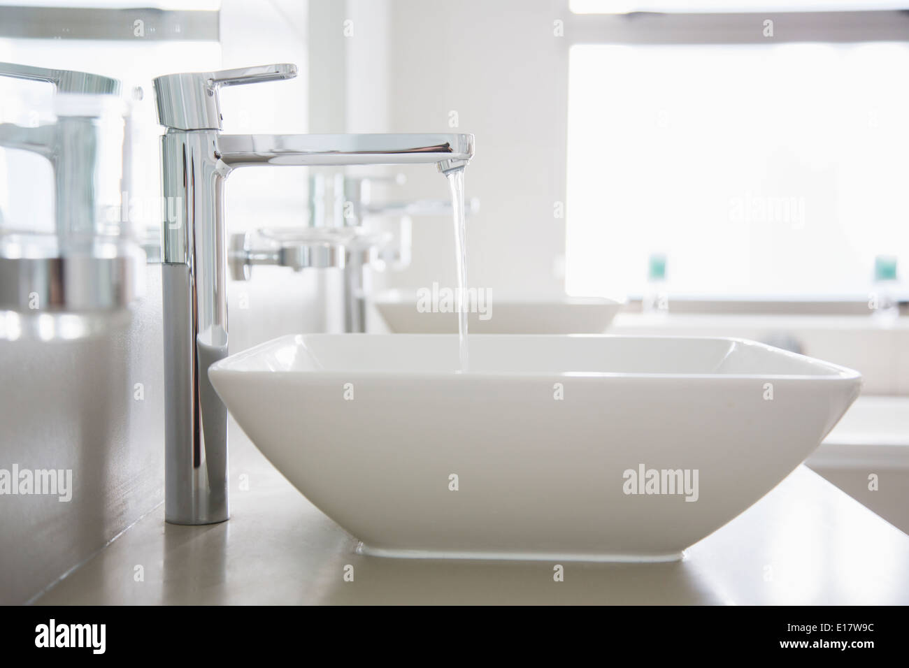 Versare acqua dal rubinetto nel bagno moderno Foto Stock