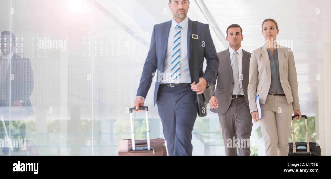 La gente di affari tirando le valigie in corridoio Foto Stock