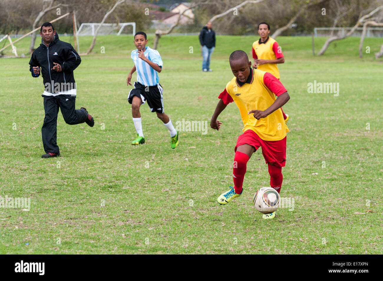 Giocatore di football in esecuzione con la palla, arbitro guardando, Cape Town, Sud Africa Foto Stock