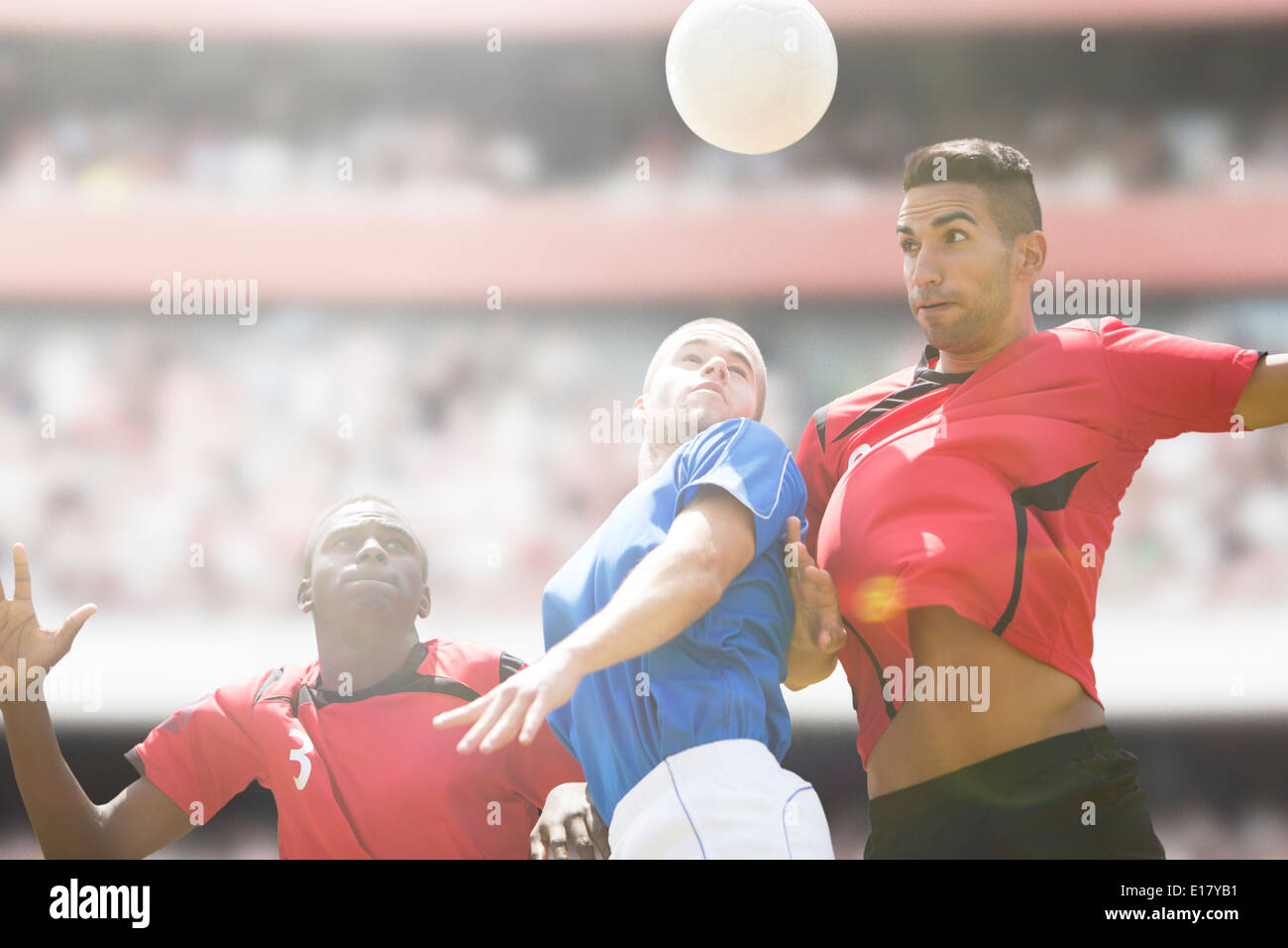 I giocatori di calcio saltando per la palla sul campo Foto Stock I giocatori di calcio saltando per la palla sul campo Foto Stock
