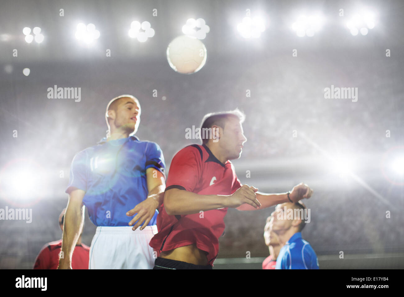 I giocatori di calcio saltando per la palla sul campo Foto Stock I giocatori di calcio saltando per la palla sul campo Foto Stock