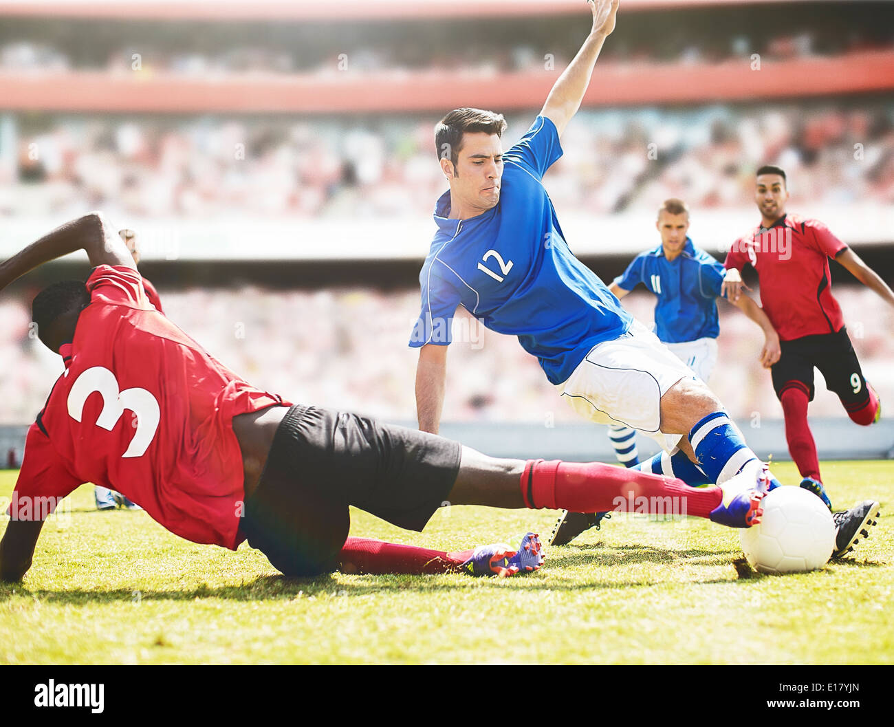 I giocatori di calcio calci palla sul campo Foto Stock