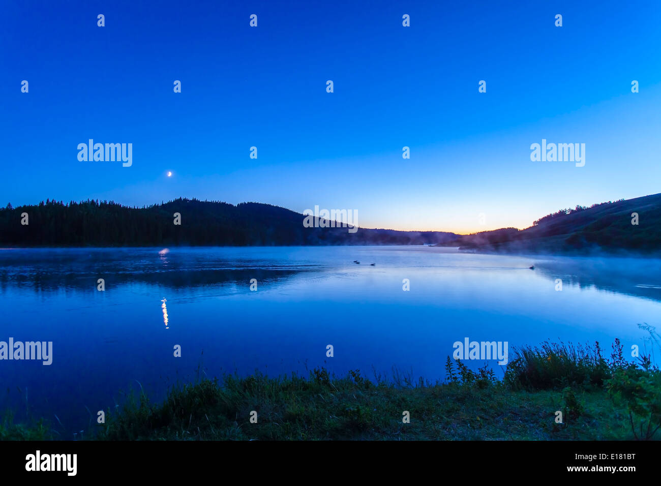 La luna crescente impostazione Reesor sopra il lago di Cypress Hills parco interprovinciale, sul lato di Alberta. Foto Stock