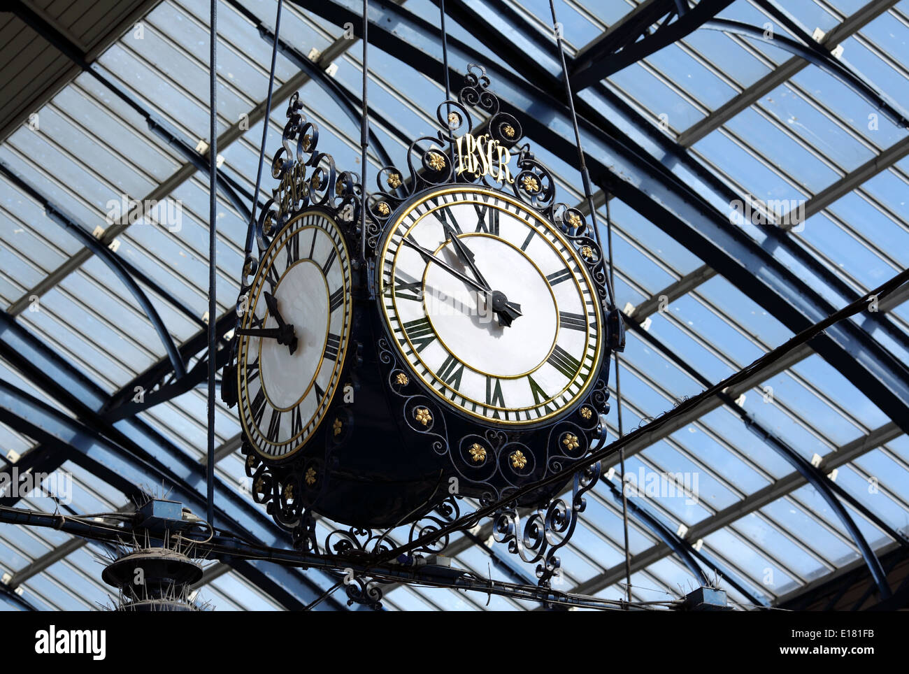 Ornato vecchio orologio appeso dal tetto nella stazione di Brighton. Foto Stock