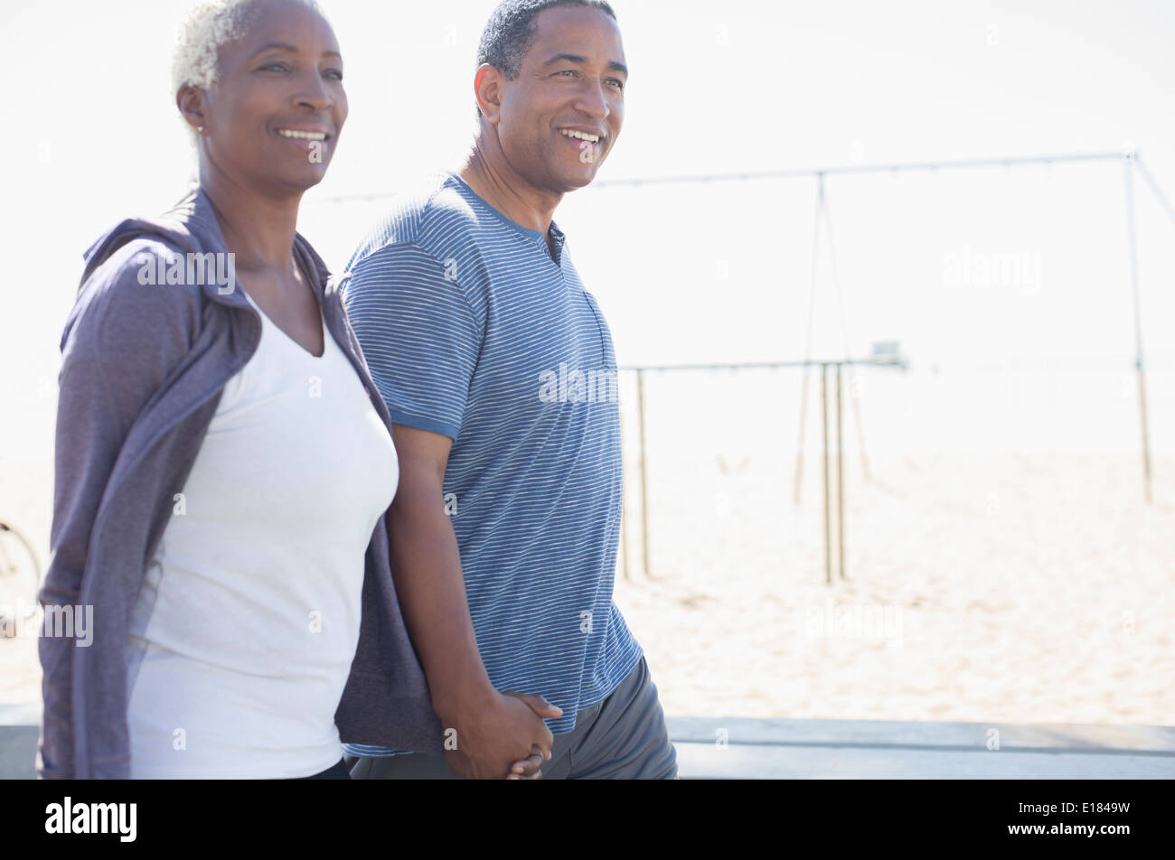 Coppia senior tenendo le mani e piedi Foto Stock