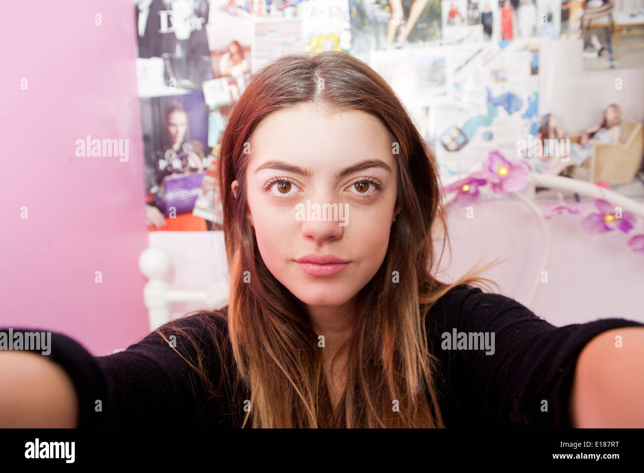 13 adolescenti anno vecchia ragazza in posa per una finta selfie nella sua camera da letto Foto Stock