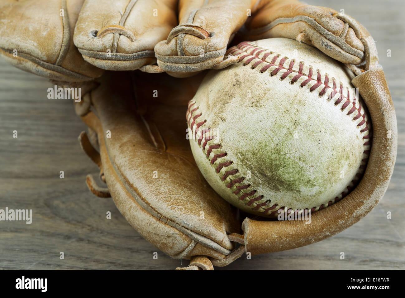 Closeup foto orizzontale vecchio e sporco all'interno di baseball di usato pesantemente guanto sul legno rustico Foto Stock