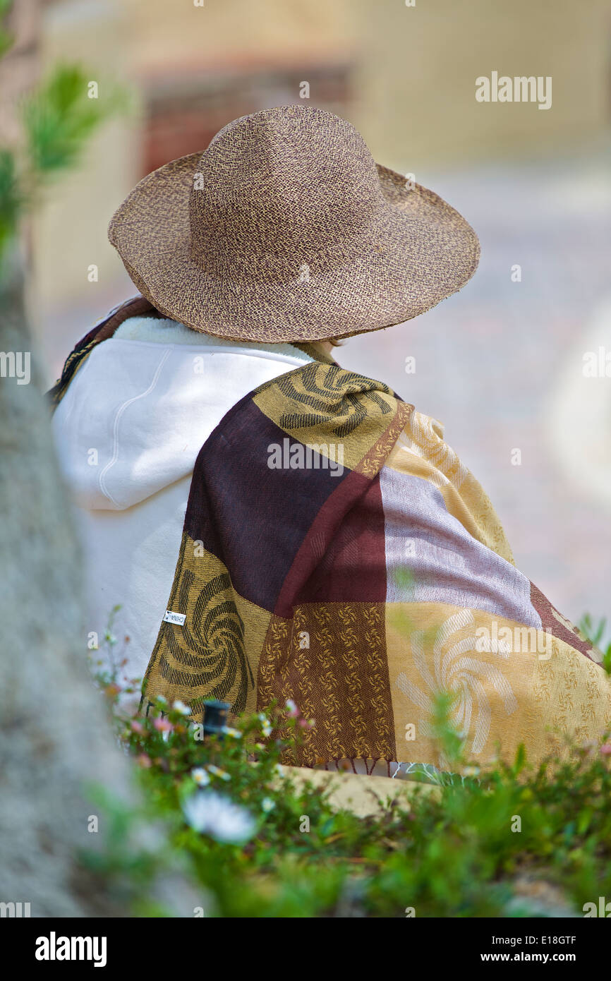 Signora in un cappello, seduti in spiaggia in Crescent Ave, Avalon, Isola di Santa Catalina, California. Foto Stock