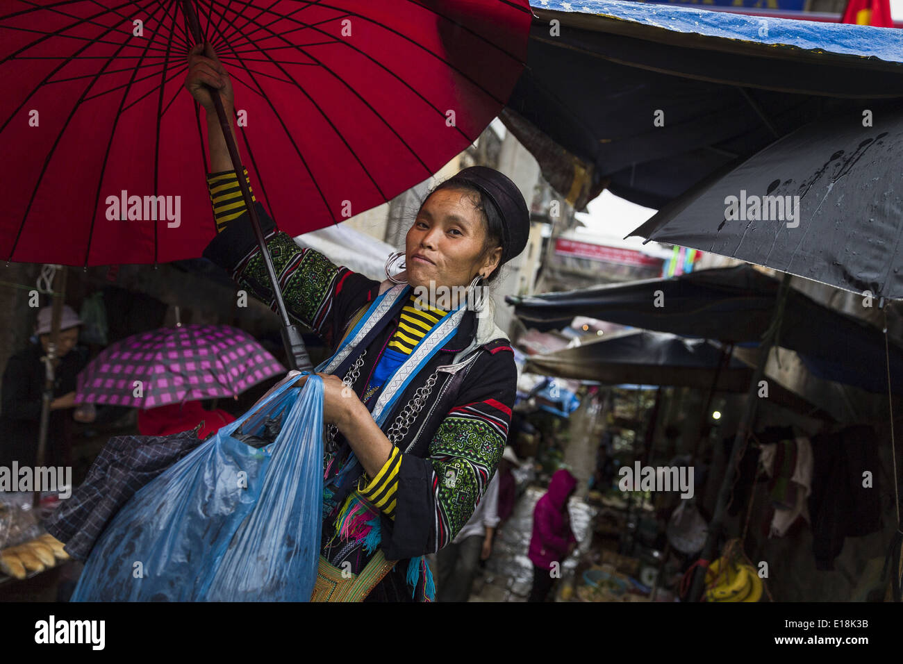 Una donna appartenente all'H'MONGS gruppo etnico con un ombrello, nel mercato di sapa Foto Stock