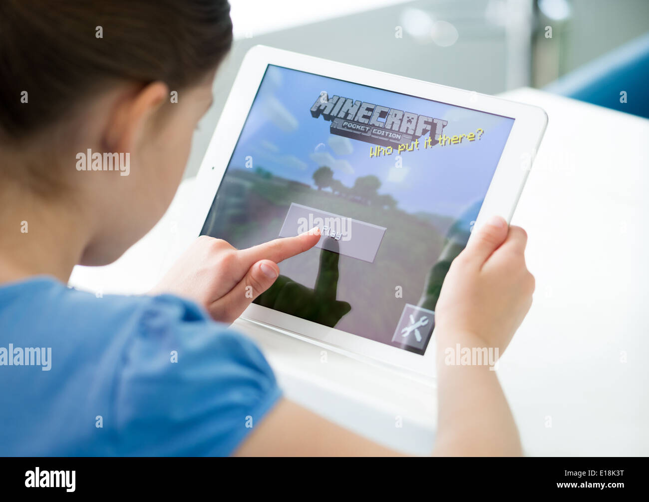 Bambina inizia a giocare Minecraft gioco su un nuovo iPad di Apple dell'aria. Minecraft è gioco molto popolare per i dispositivi mobili Foto Stock