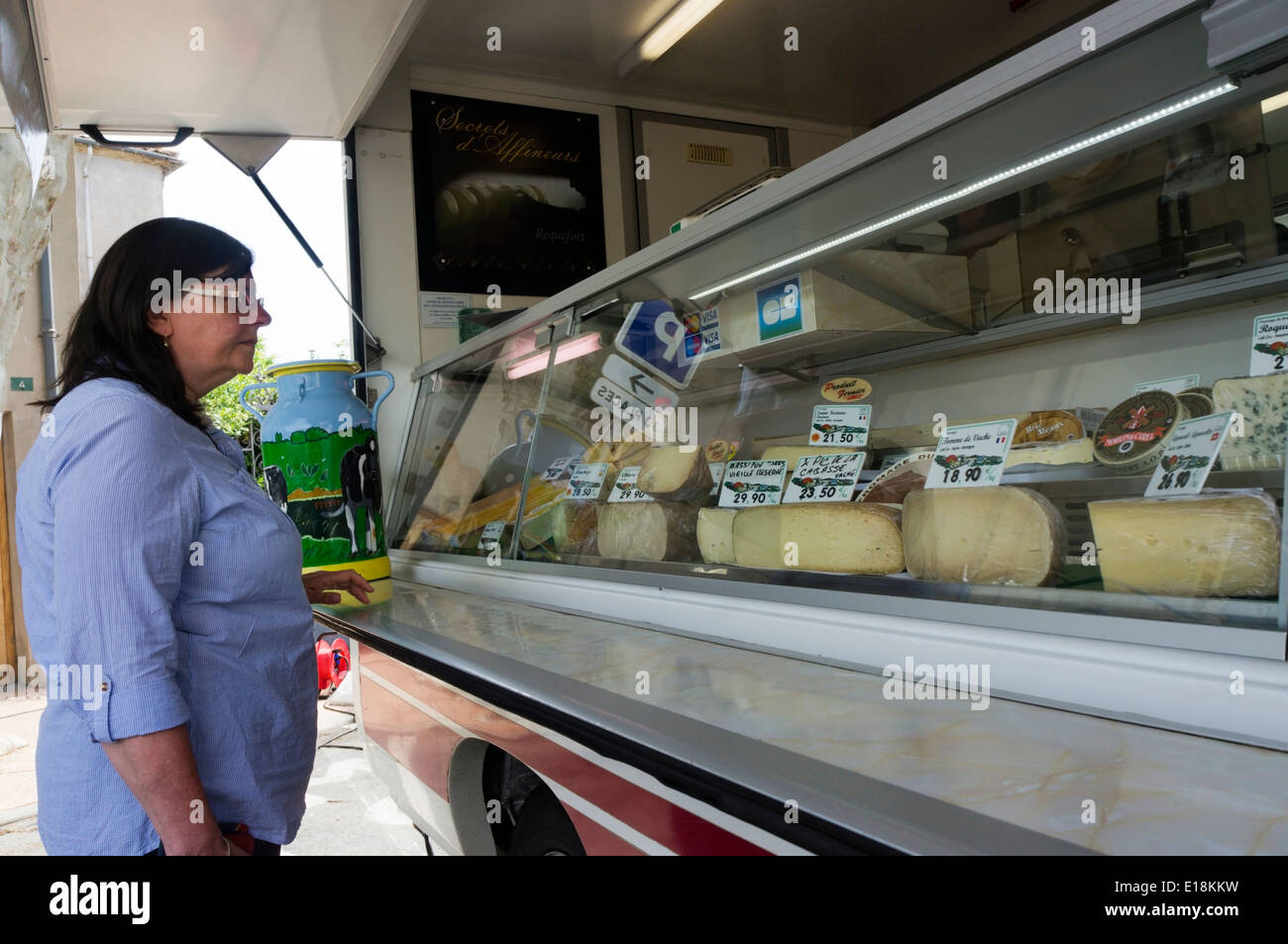 Una donna di acquistare il formaggio da un formaggio di viaggio van sul mercato francese. Foto Stock