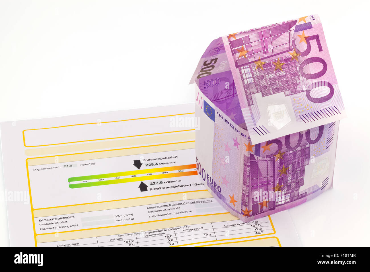Ein Haus gebaut aus Eurogeld scheinen und einem Energieausweis. Bausparen, Hausbau und Hauskauf. Foto Stock