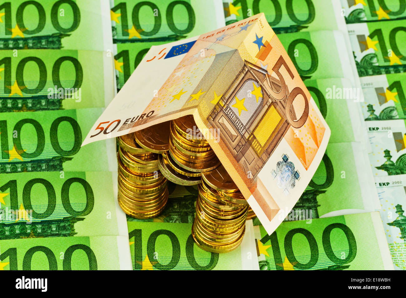Ein haus aus Geld und Münzen Geldscheinen. Symbolphoto für Hausbau und Bausparen Foto Stock