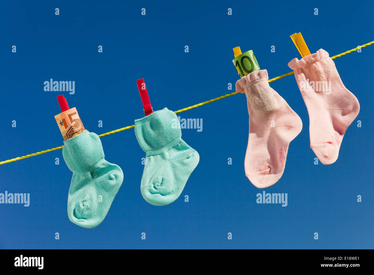 Baby Socken auf W‰scheleine mit Eurogeldscheinen. Il Blauer Himmel. Foto Stock