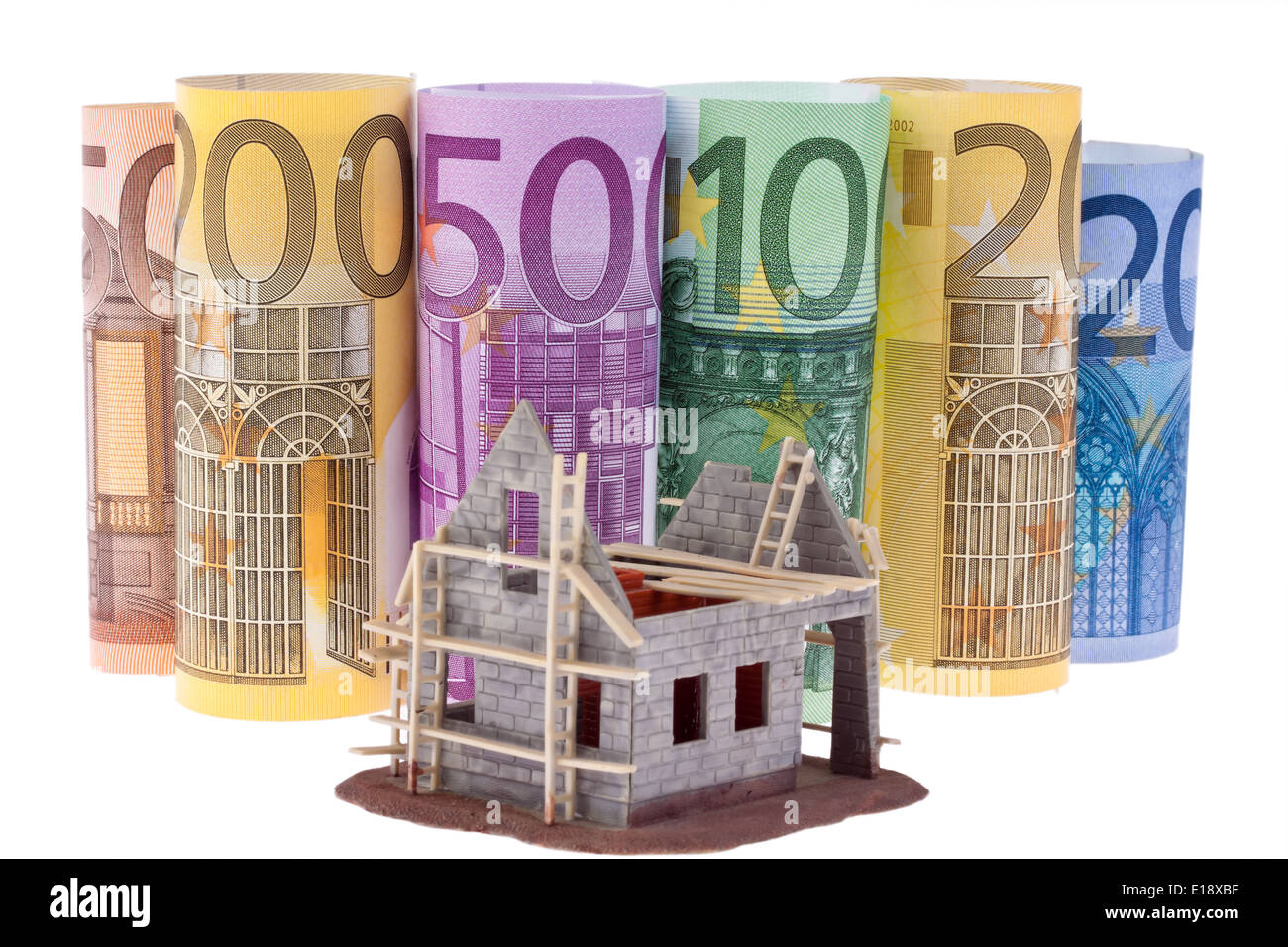 Viele Euro Geldscheine Rohbau mit Haus. Vor weissem Hintergrund Foto Stock