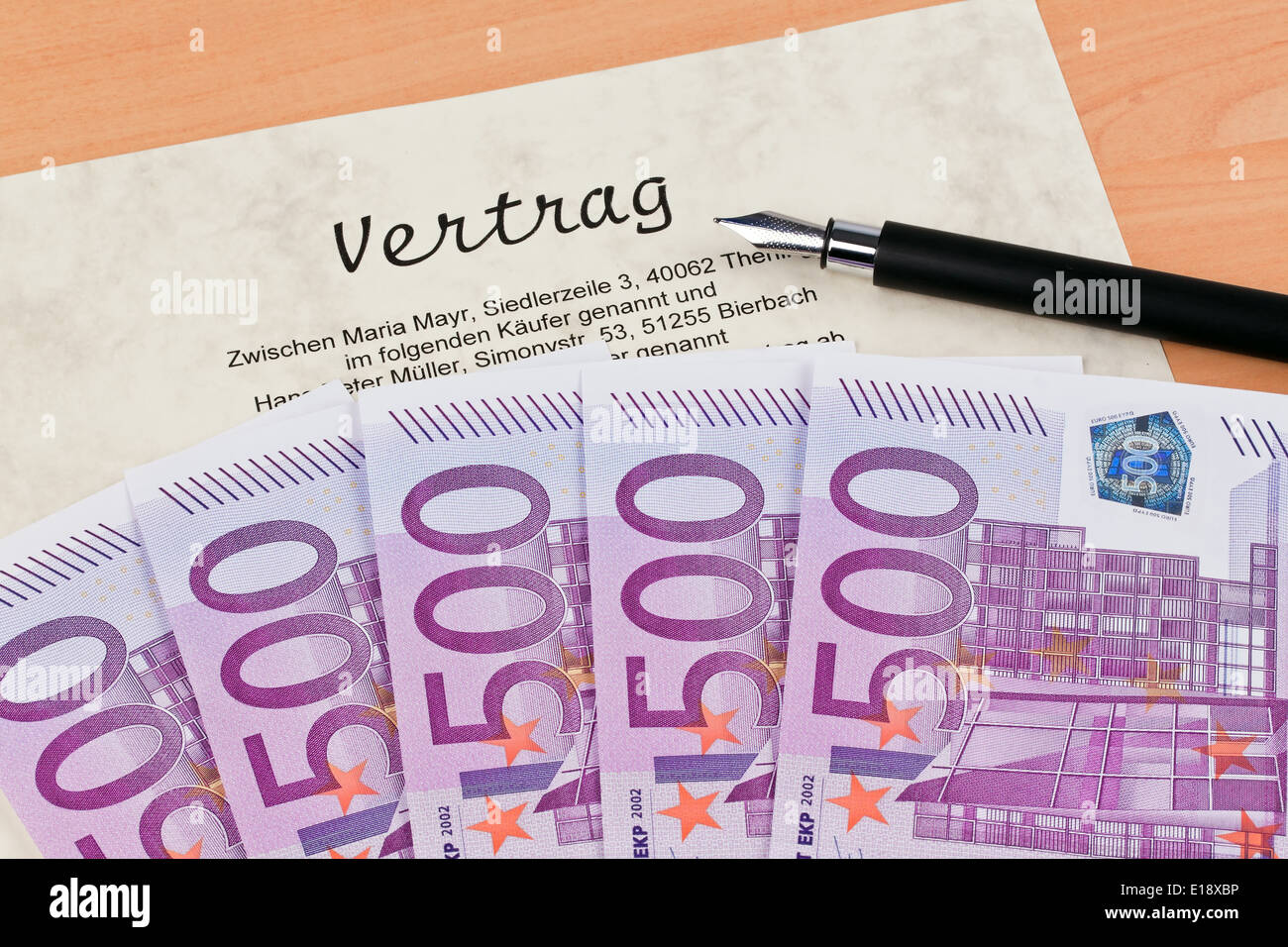 Viele Euro Geldscheine und ein Vertrag liegen nebeneinander. Foto Stock