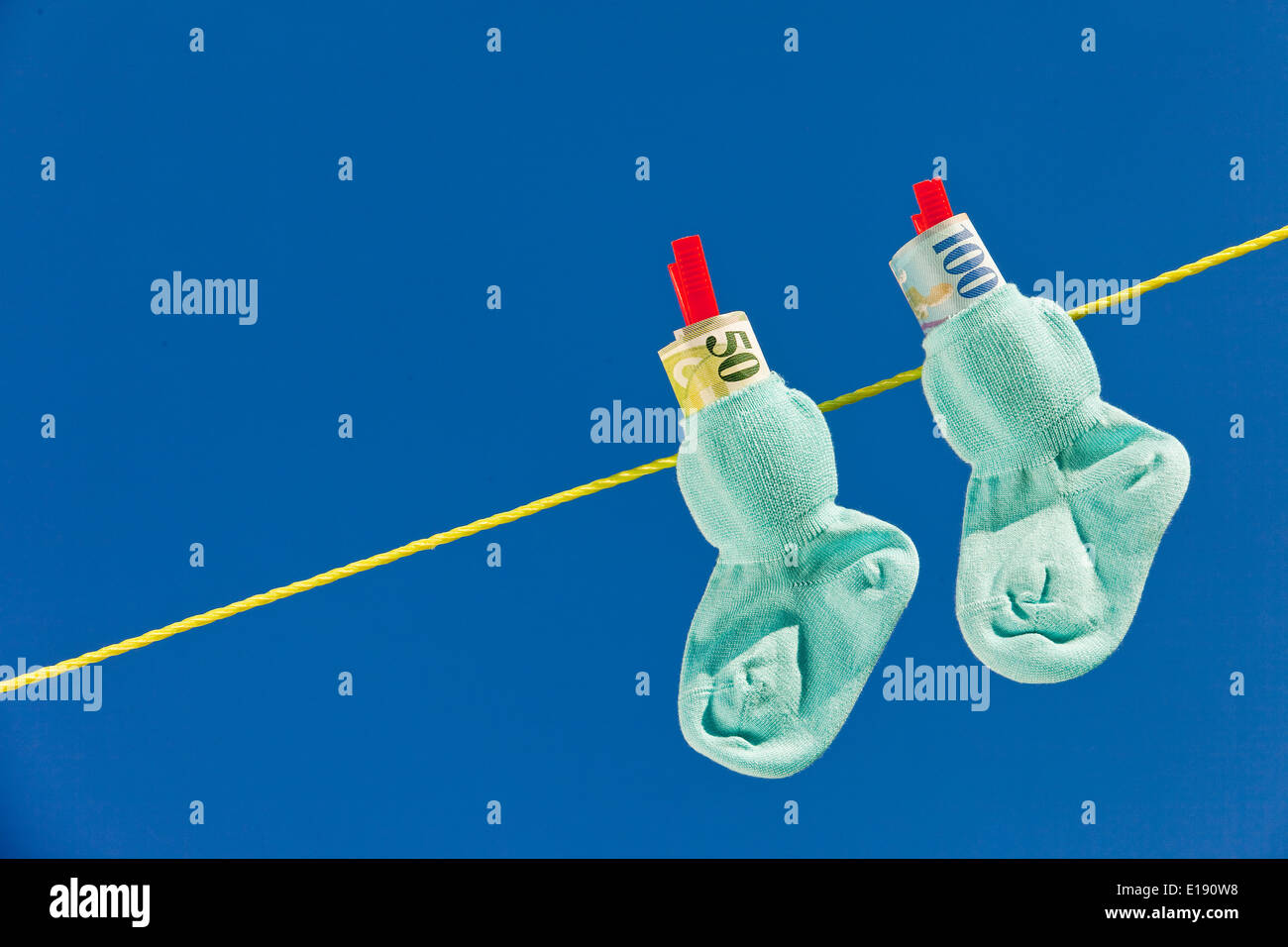 Baby Socken auf W‰scheleine mit Schweizer Franken. Il Blauer Himmel. Foto Stock