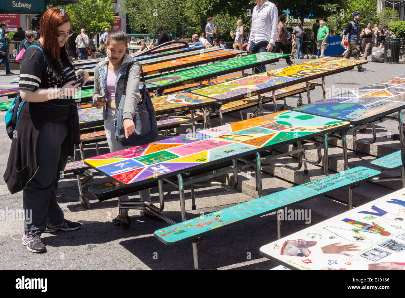 Scuola tabelle lunchroom decorato con arte in rappresentanza di varie questioni sociali sono visti in Union Square Park a New York Foto Stock
