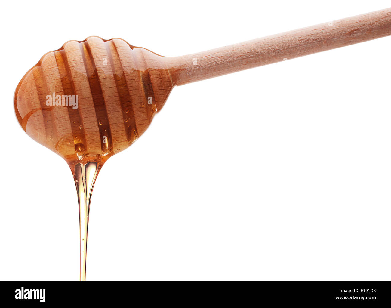 Il miele il gocciolamento da un miele di legno isolata del bilanciere su sfondo bianco intaglio Foto Stock