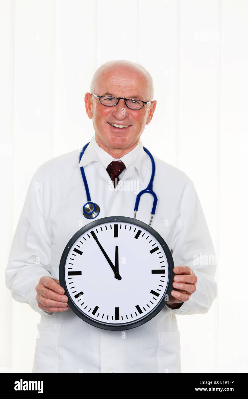Ein Arzt h‰lt eine Uhr. Auf dem Ziffernbaltt ist es 5 Minuten vor 12 Foto Stock