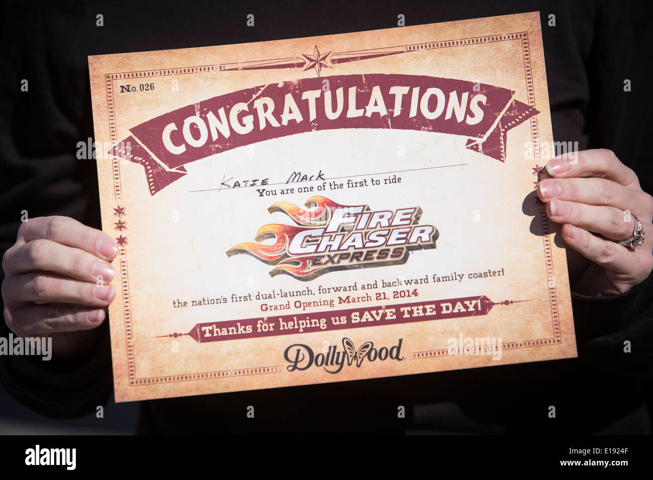 Una donna presenta un certificato di spettacolo, lei è stato uno dei primi a guidare la FireChaser Express roller coaster in Dollywood Foto Stock