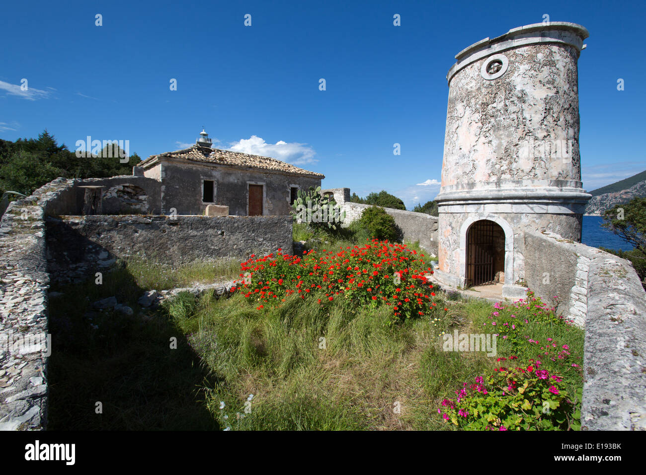 Villaggio di Fiskardo, Cefalonia. Rovine della veneziana del XVI secolo e faro di luce-keepers house. Foto Stock