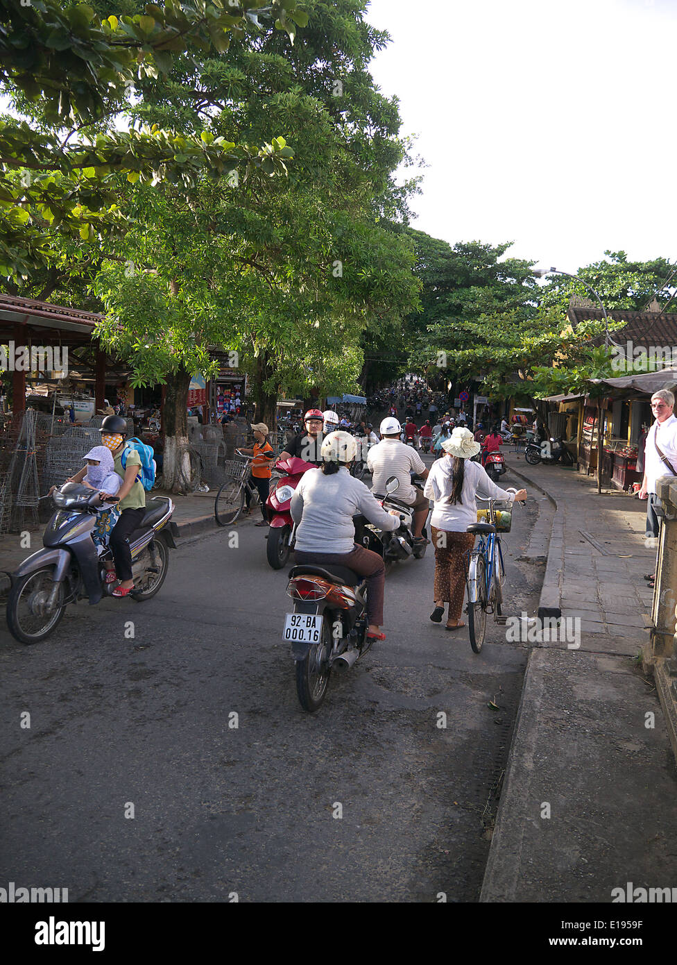 Ciclisti e motociclisti in Hoi Ann Vietnam Foto Stock