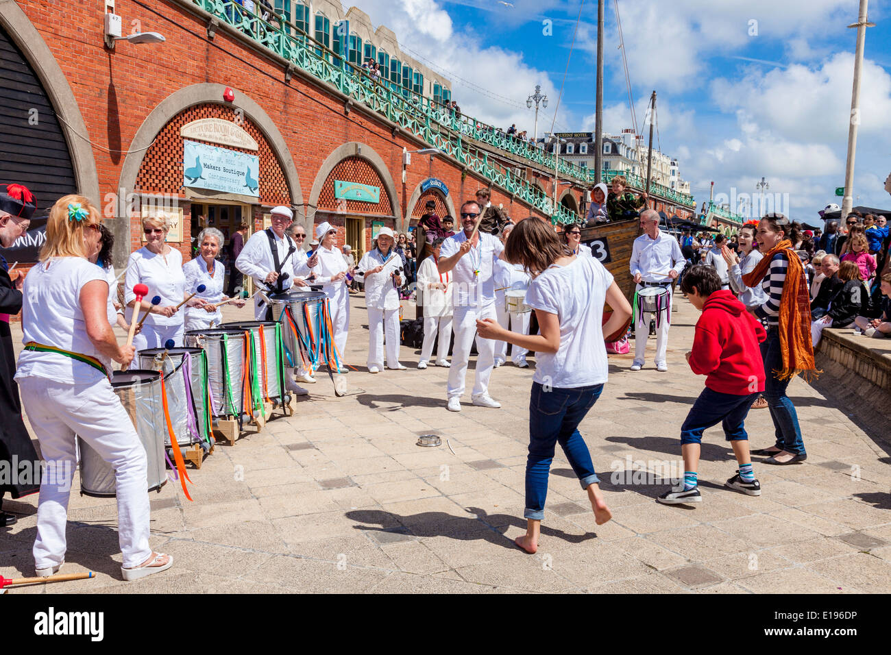 I bambini danza al Silver suoni banda Samba al sgombro Fayre, Brighton Seafront, Sussex, Inghilterra Foto Stock