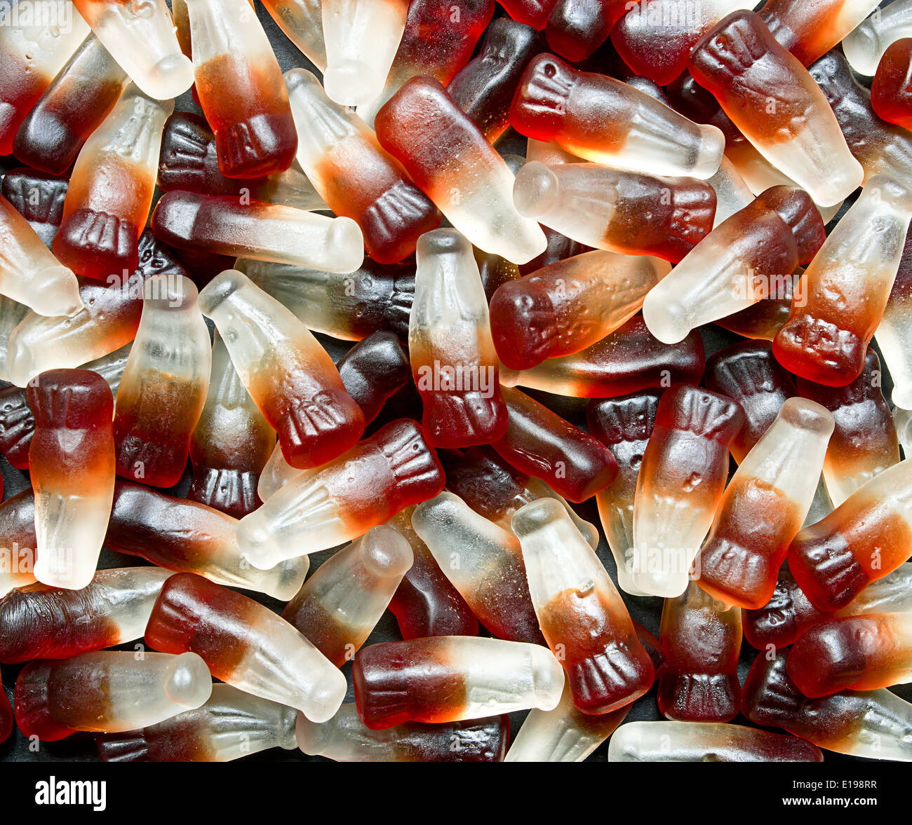 Fragrante Bottiglia di Cola sullo sfondo di un popolare retrò dolce noto anche come caramella gommosa a scegliere e combinare self service sul mercato. Foto Stock