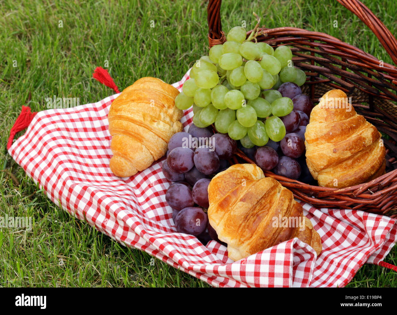 Pic nic sul prato verde con uve e croissant Foto Stock