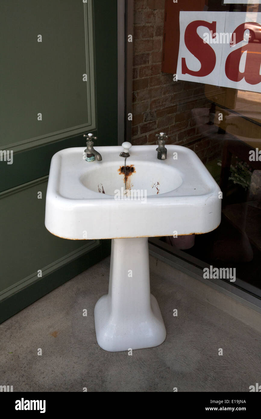 Vecchio ghisa lavandino davanti a un negozio Foto Stock