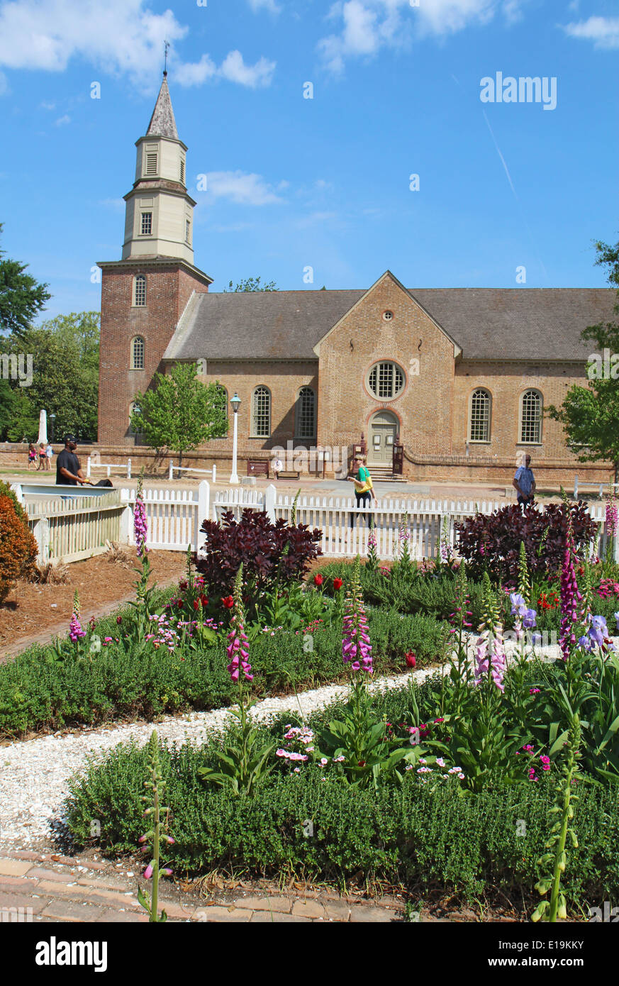 Giardini di Colonial Williamsburg e Bruton Parish Chiesa Episcopale in Virginia, contro un luminoso cielo blu verticale Foto Stock