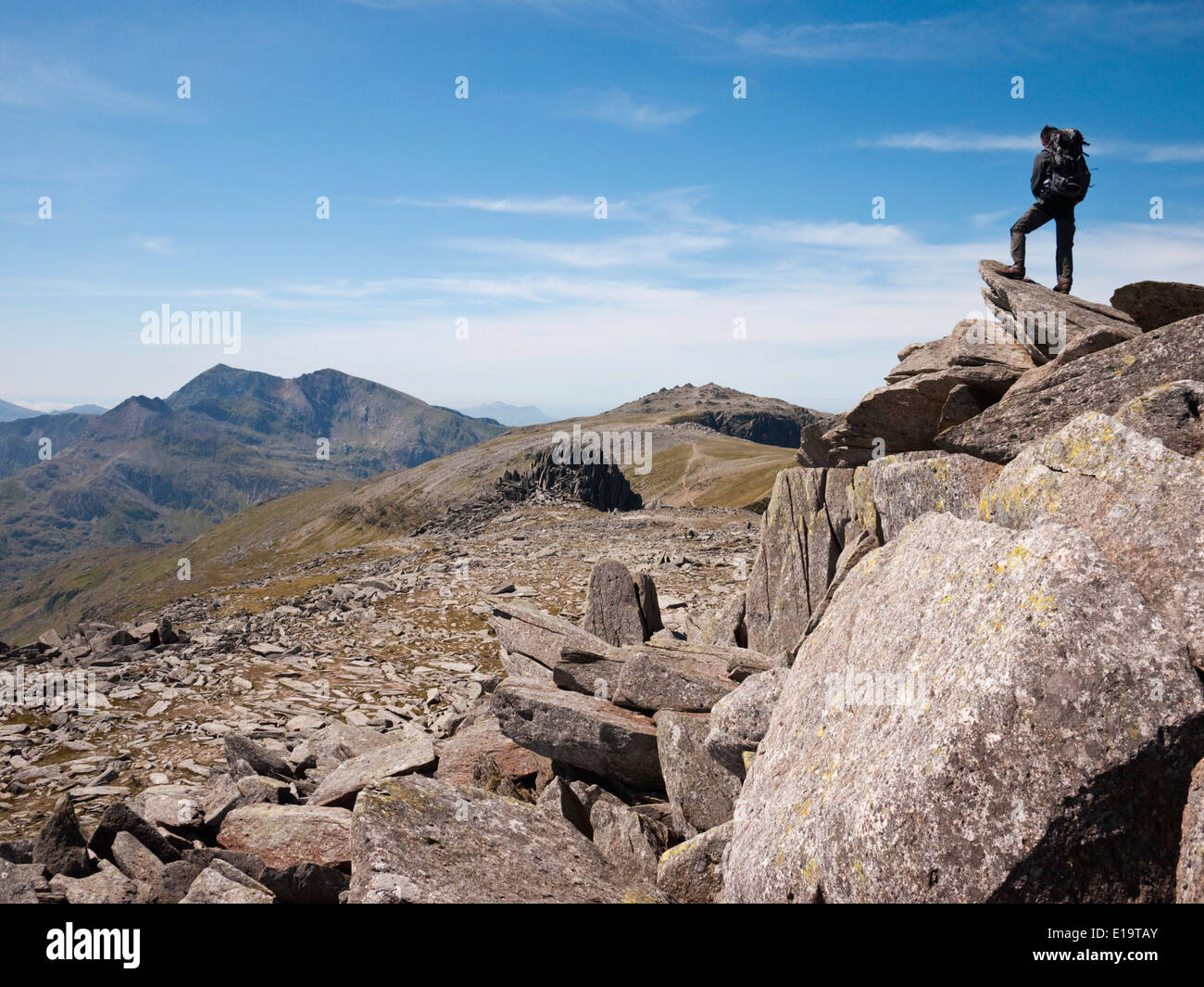 Un viandante si ammira la vista del massiccio Snowdon dal vertice rocce di Glyder Fach, in Snowdonia Glyderau della montagna. Foto Stock