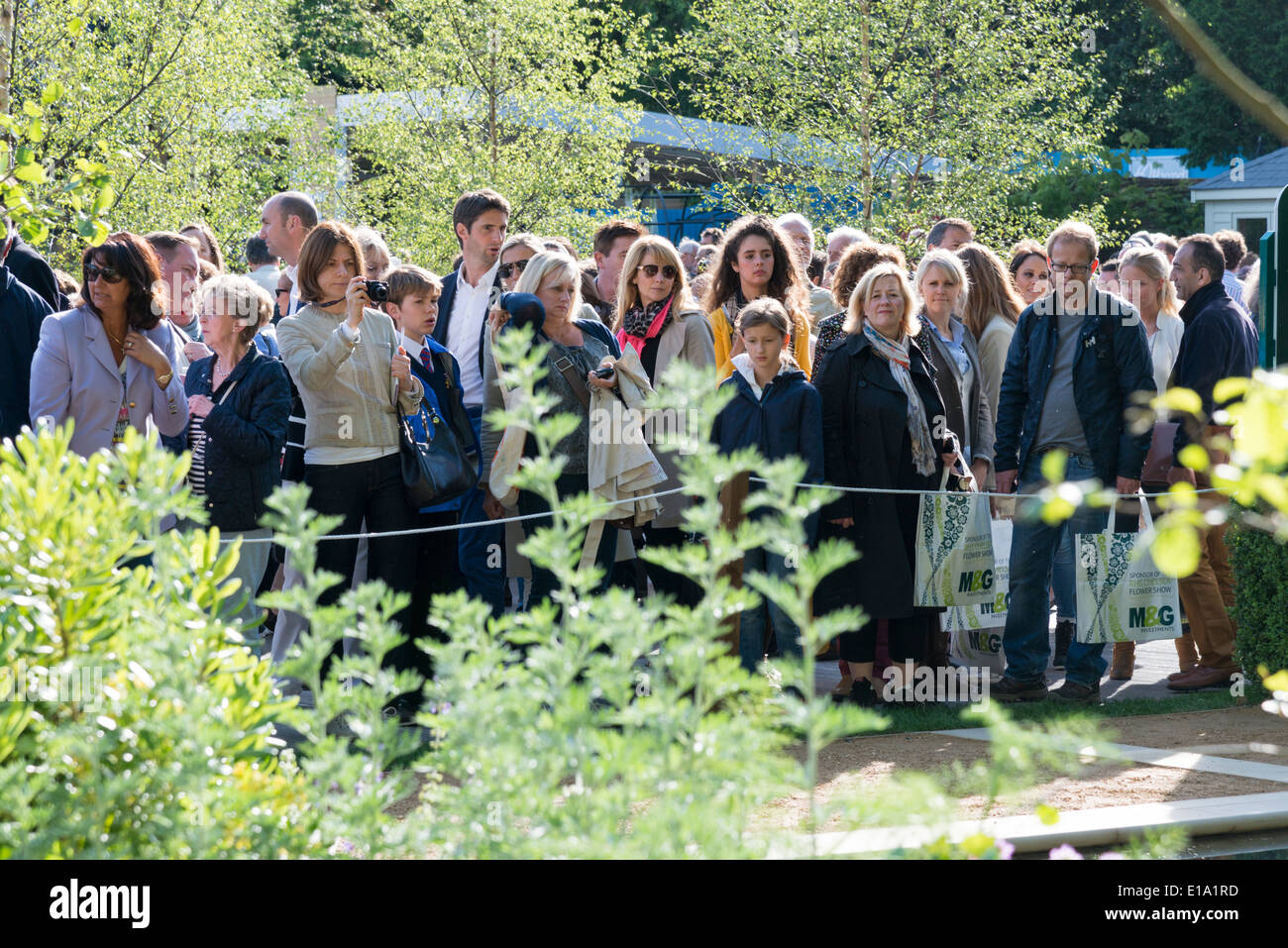 Spettatori o visitatori del Chelsea Flower Show 2014 guardare uno spettacolo giardino. Foto Stock