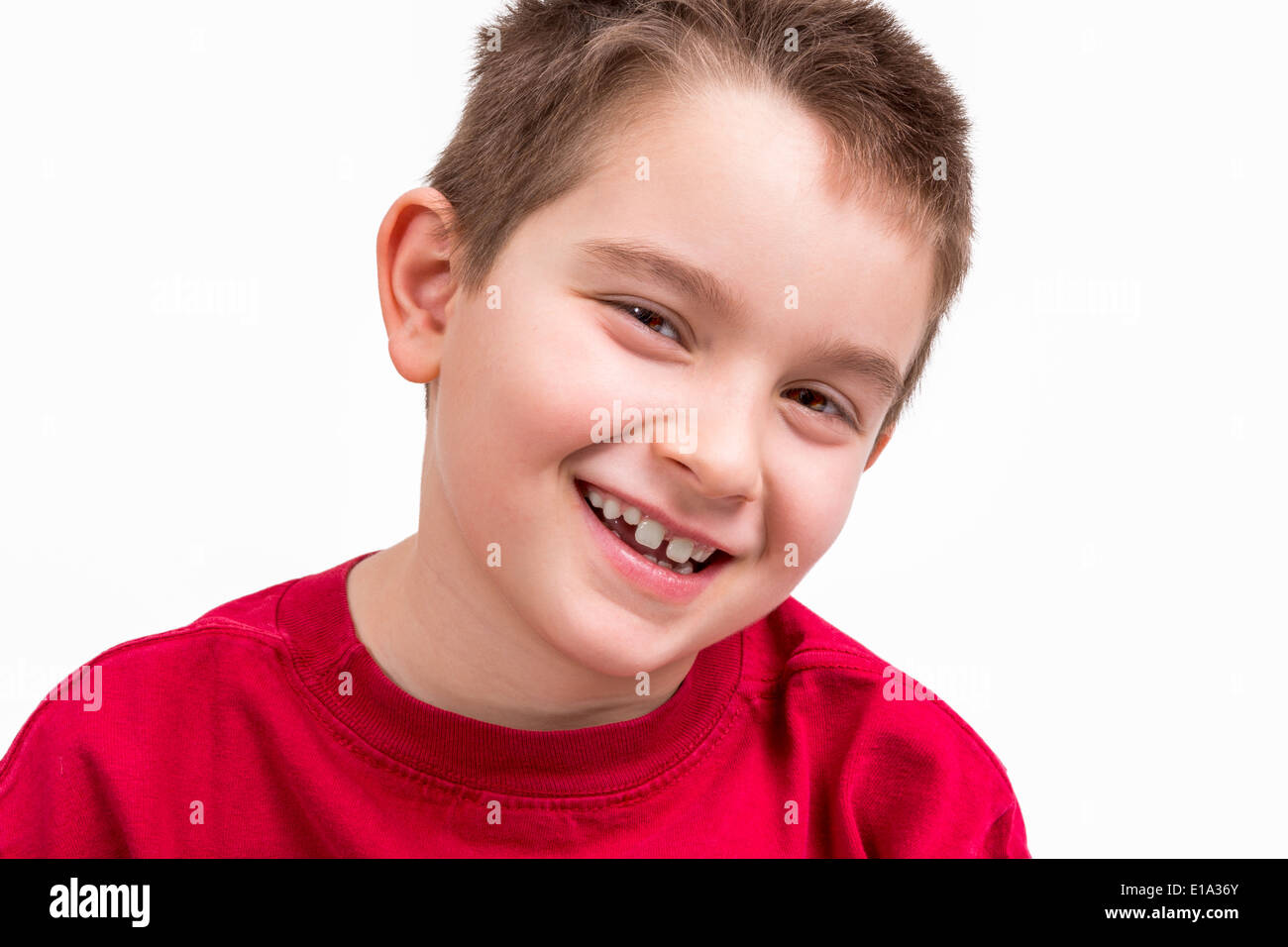 Nove yoears old boy guardando fiduciosamente la fotocamera con il suo sorriso toothy. Foto Stock
