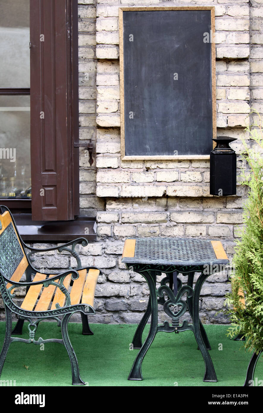 Outdoor cafe con lavagna vuota sulla parete per posizionare il tuo testo Foto Stock