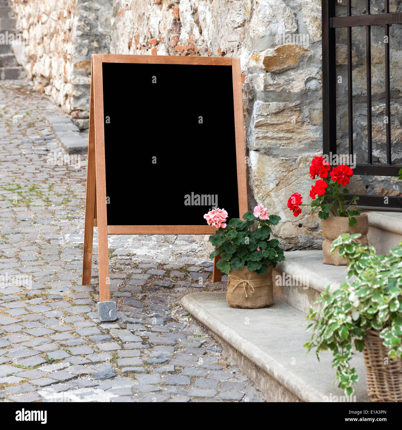 Tavola di legno per ristorante con menu spazio vuoto per aggiungere testo permanente al ristorante ingresso con vasi di fiori Foto Stock