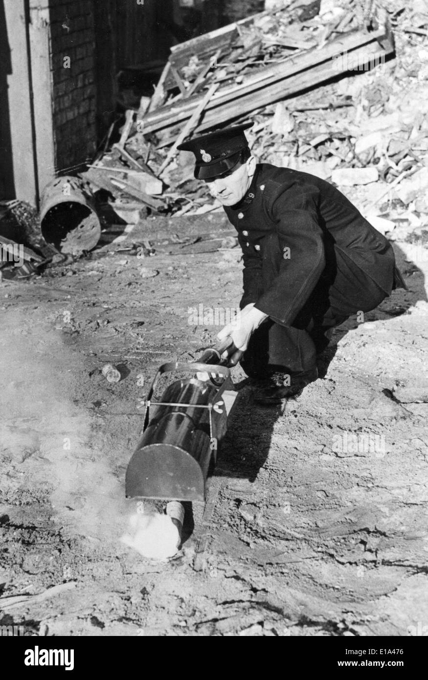 BRITISH HOME FRONT WW2 un vigile del fuoco si estingue una bomba incendiaria Foto Stock