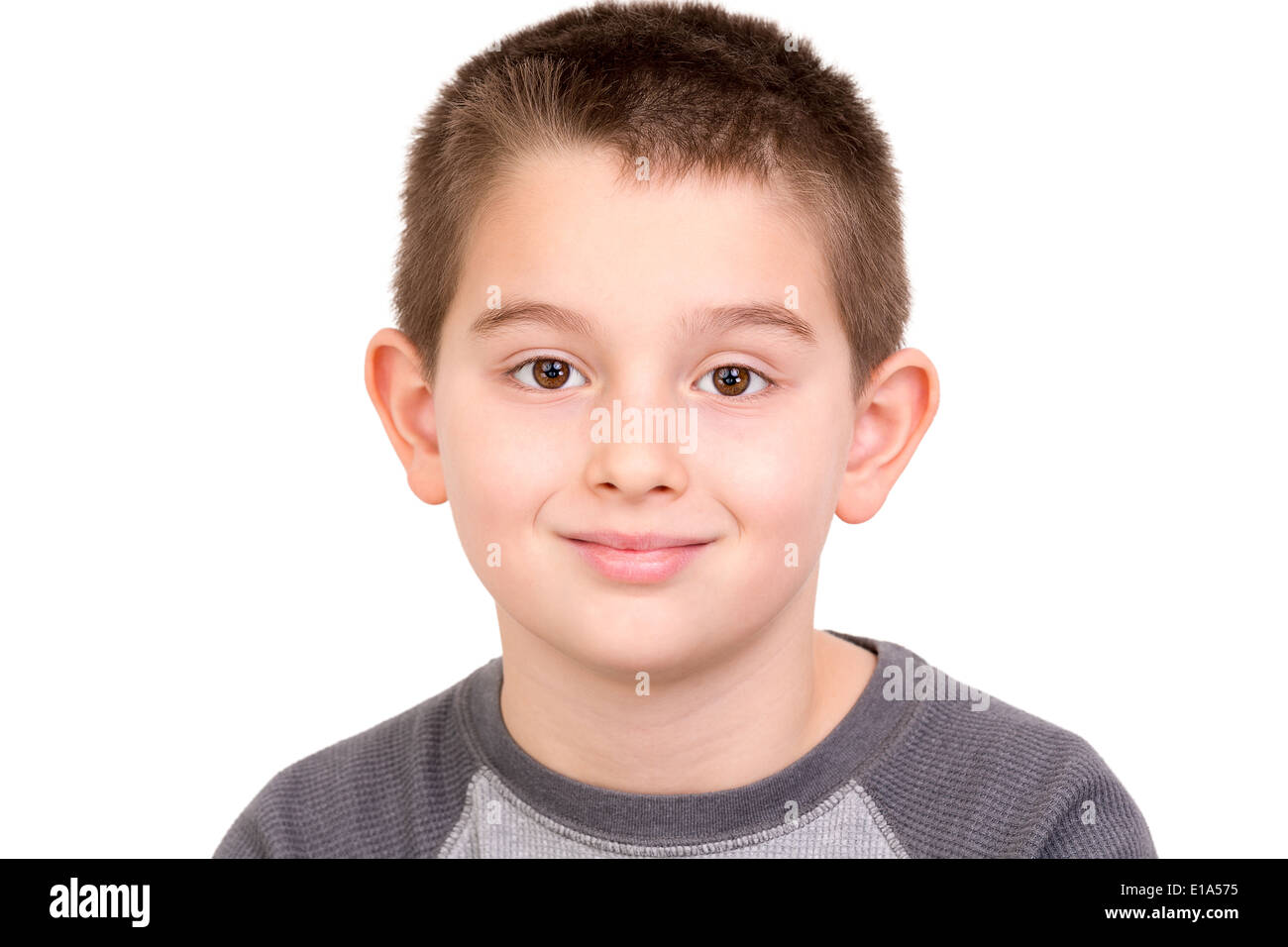 Ragazzo elementari guardando a voi realmente e naturalmente con i suoi occhi marroni Foto Stock